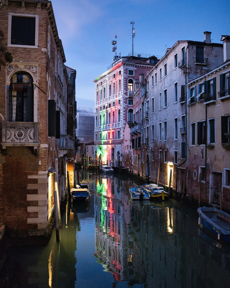 Le luci di Venezia riflesse in un canale al crepuscolo.