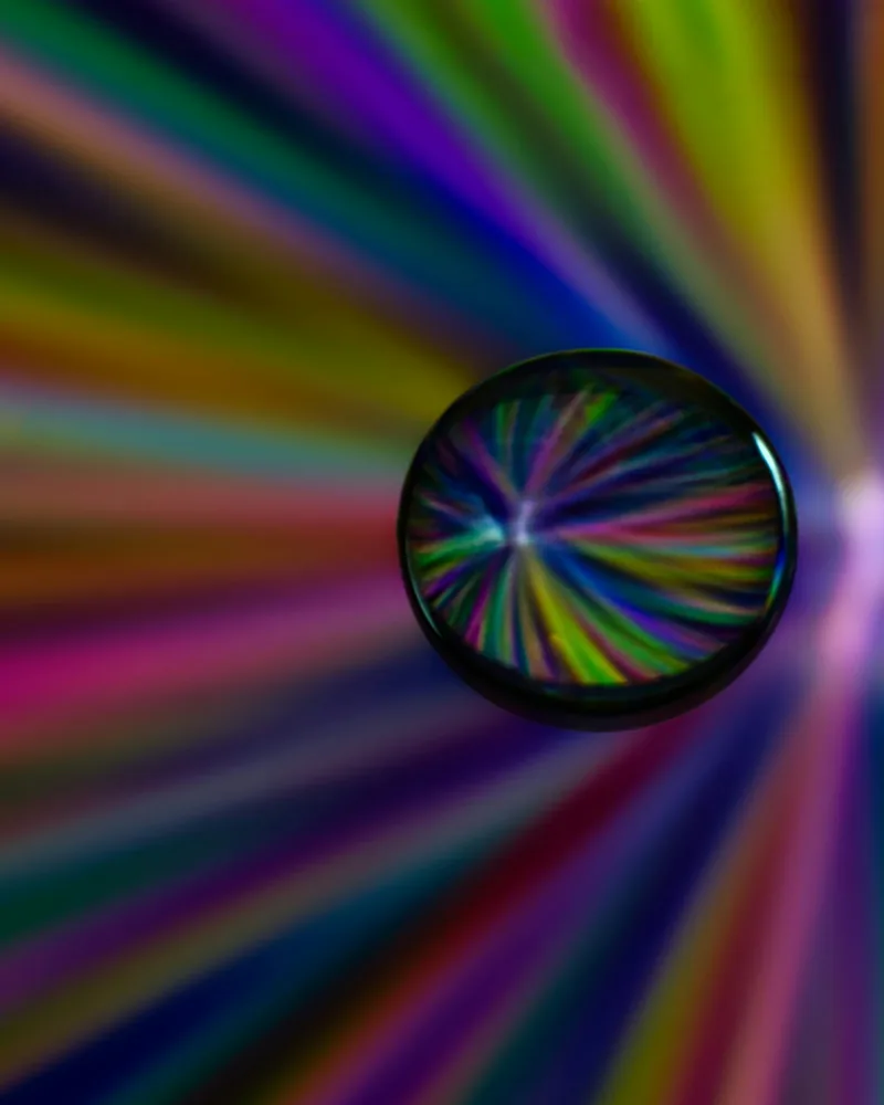 Una sfera di vetro rifrange luci colorate.