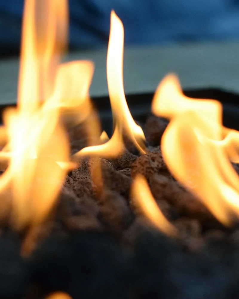 Fiamme arancioni che danzano contro uno sfondo scuro.