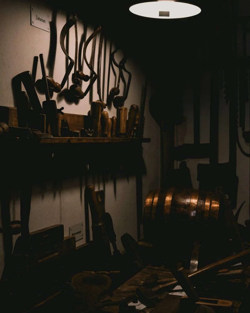 Attrezzi in una bottega artigiana illuminata da una lampada.